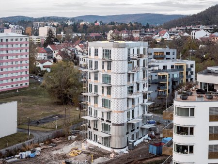 Dům se začal stavět v polovině roku 2022 a nyní se dokončuje. Po obvodu umístěné pobytové místnosti doplňují prostorné balkony.