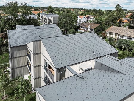 Na budovách byly použity PREFA střešní panely R.16 v barvě P.10 tmavě šedá. Všechny klempířské doplňky, okna a balkonová zábradlí, ale také protipožární fasádní oplechování mezi podlažími mají stejnou barvu jako hliníková střecha.